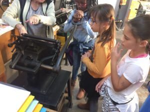 Kultur macht stark-Projekt 2019: 3 Kinder und eine Betreuerin an der Druckpresse in Lindener Druckerei-Museum